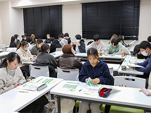 説明に熱心に耳を傾ける学生
