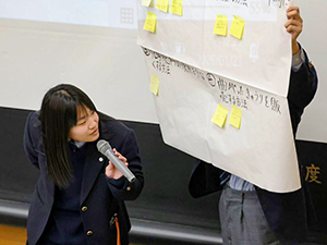 グループ討論の結果を発表する女子学生