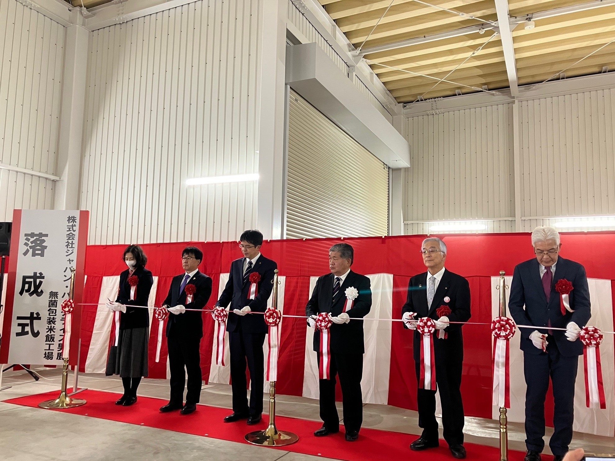 涌井代表取締役社長(右から3人目)、 来賓によるテープカット