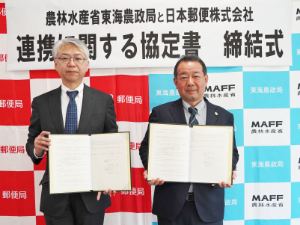 協定書を手にする日本郵便株式会社根岸常務執行役員東海支社長と東海農政局秋葉局長