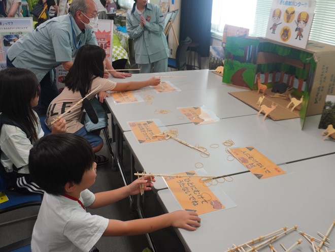 輪ゴム鉄砲で農作物を荒らす鳥獣を狙う子どもたち