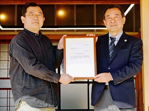 株式会社つじ農園の農泊施設「Kou」で認定通知書を手にする辻武史代表取締役（左）と秋葉東海農政局長（右）