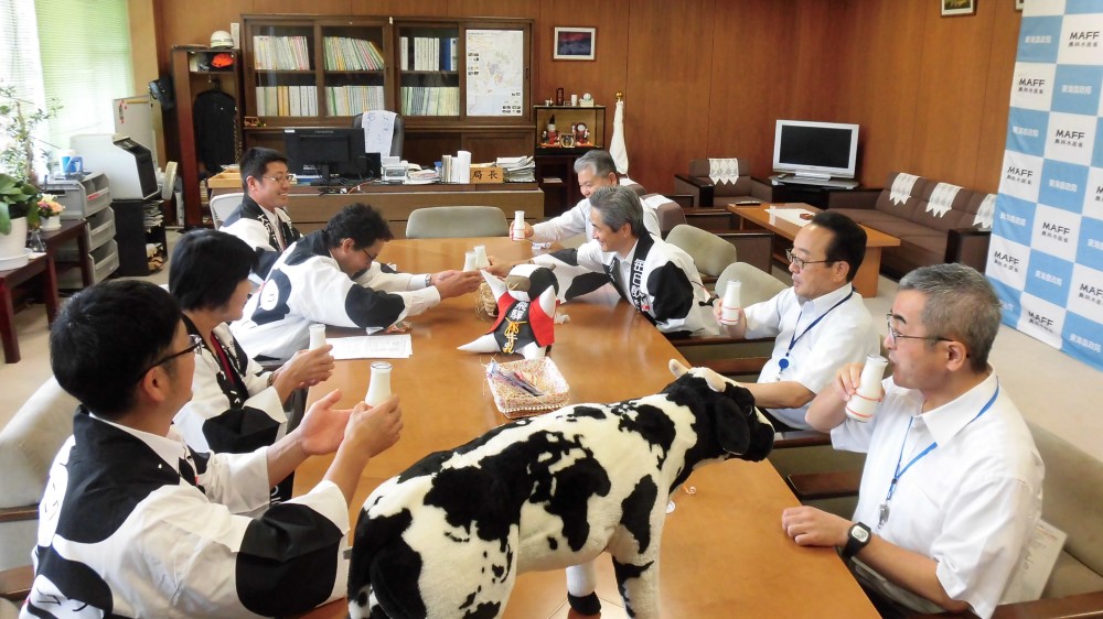 牛乳で乾杯する関係者一同
