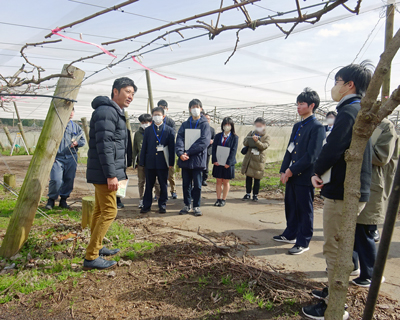 ほ場で浅井専務から説明を受けている学生