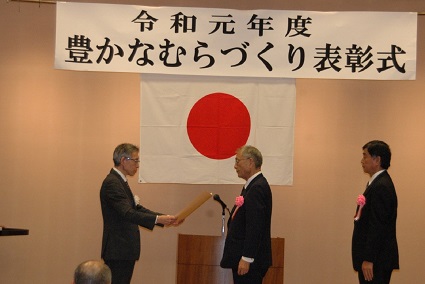 富田局長（左）から農林水産大臣賞を受ける「加子母むらづくり協議会」の中島会長（中央）及び中島副会長（右）