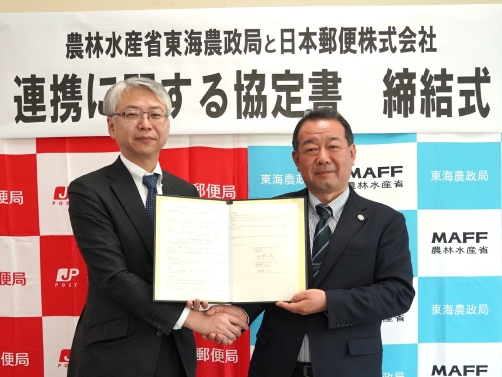 協定書を手に記念撮影を行う、日本郵便株式会社 根岸常務執行役員（東海支社長）（左）と東海農政局 秋葉局長（右）