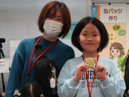 自分が作成した缶バッジを手に持った子供1