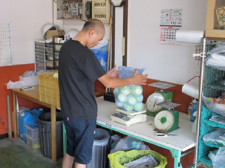 卸部門の出荷作業をする夫の克浩さん